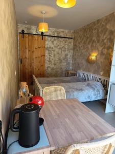 a room with a bed and a table with a tea kettle on it at La Única in Coín