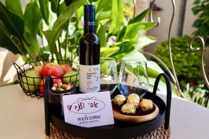 a bottle of wine and a plate of food on a table at Cnaan Village Boutique Hotel & Spa in Had Nes