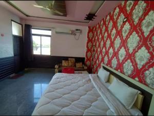 a bedroom with a bed and a red wall at Surya hotel in Gangāpur