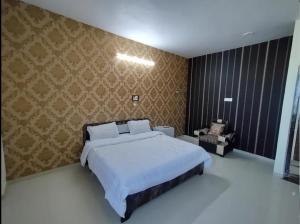 a bedroom with a large bed and a chair at Surya hotel in Gangāpur