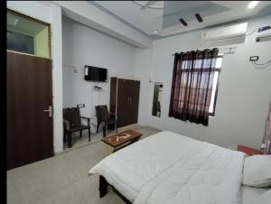 a bedroom with a bed and a table and a chair at Surya hotel in Gangāpur