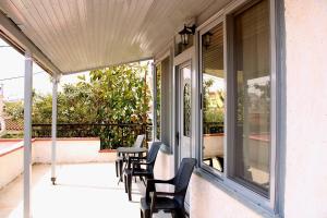 a screened porch with chairs and a table at Komninos' Traditional House in Artemida