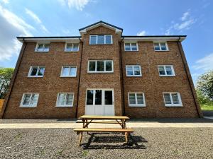 a picnic table in front of a brick building at Inchmoan Apartment in Bonhill
