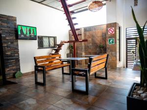 a dining room with two benches and a table at Royal Lodge in Sibasa +8 photos