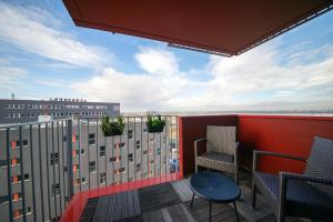 a balcony with chairs and a view of a building at Appart' du Trident in Mulhouse