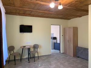 a room with a table and chairs and a tv at Apartments House Pylypets in Pilipets