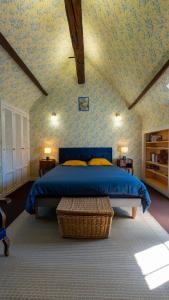 a bedroom with a bed with a blue comforter at Le clos du cèdre in Cellettes