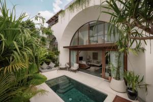 an indoor pool in a house with plants at Suasana by AYA in Uluwatu