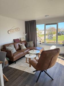 a living room with a couch and a table at Chalet 130 in Petten