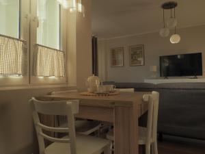 a dining room table with two chairs and a television at Apartament Secundus in Ełk +7 photos