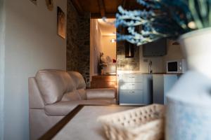 a living room with a chair and a kitchen at Corte d'Arnosto - Casa Virginia in Fuipiano Valle Imagna