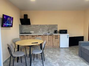 a kitchen with a table and chairs in a room at Apartments House Pylypets in Pilipets
