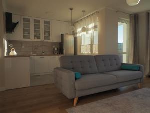 a living room with a couch and a kitchen at Apartament Secundus in Ełk
