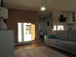 a living room with a couch and a brick wall at Apartament Secundus in Ełk