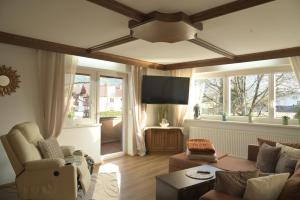 a living room with a couch and a flat screen tv at Appartement Naunspitzblick in Ebbs