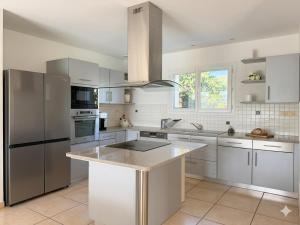 a kitchen with white cabinets and stainless steel appliances at Domaine de Quintessence in Saint-Justin
