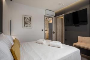 a bedroom with a bed with two white towels on it at Kallithea living in Koskinou