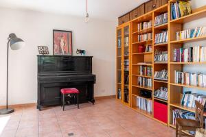 a living room with a piano and book shelves at Villa Galante in Meylan