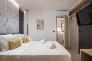 a bedroom with a white bed with towels on it at Kallithea living in Koskinou