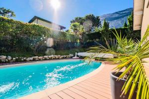 a swimming pool with a potted plant next to a house at Villa Galante in Meylan