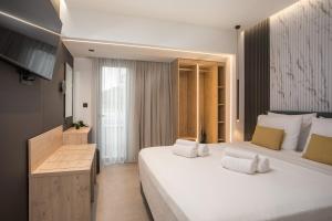 a hotel room with two beds and a desk at Kallithea living in Koskinou