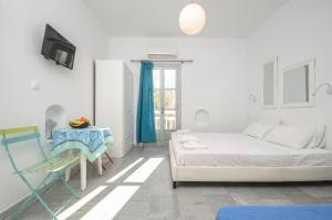 a white room with a bed and a chair at Depis suites naxos in Naxos Chora
