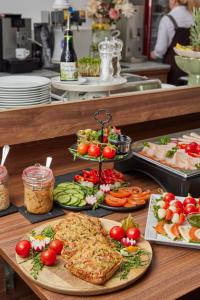 a buffet with plates of food on a table at I AM HOTELS Leoben in Leoben +73 photos