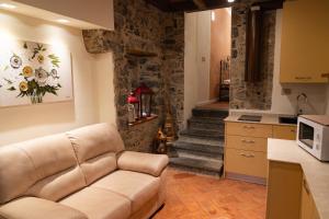 a living room with a couch and a kitchen at Corte d'Arnosto - Casa Virginia in Fuipiano Valle Imagna +22 photos