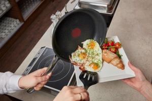 a person holding a strainer over a plate of food at I AM HOTELS Leoben in Leoben