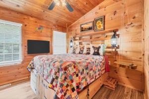 a bedroom with wooden walls and a bed with a tv at Holy Smokes in Townsend