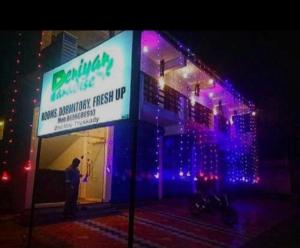 a man standing in front of a building with purple lights at PERIYAR Paradize Inn,Kumily in Thekkady