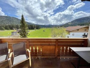 a balcony with a view of a field and mountains at Chalet Cristall Superior Appartement 8 in Leutasch