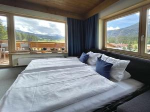 a bedroom with a large bed with two large windows at Chalet Cristall Superior Appartement 8 in Leutasch