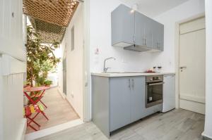 a white kitchen with a sink and a stove at Depis suites naxos in Naxos Chora