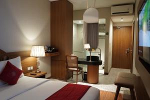a bedroom with a bed and a desk with a chair at Ramada by Wyndham Yogyakarta in Yogyakarta