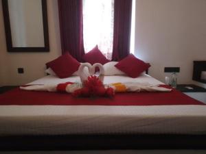 a bedroom with a bed with red and white pillows at George Bungloaw in Henegama