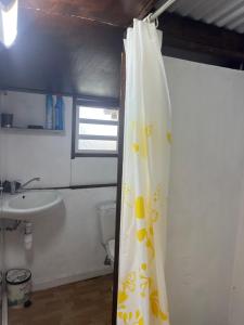 a bathroom with a sink and a shower curtain at Au pied du Piton Bellevue in Sainte-Rose
