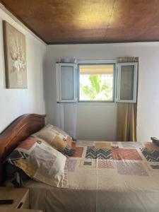 a bedroom with a bed and a window at Au pied du Piton Bellevue in Sainte-Rose