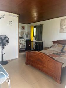 a bedroom with a wooden bed in a room at Au pied du Piton Bellevue in Sainte-Rose