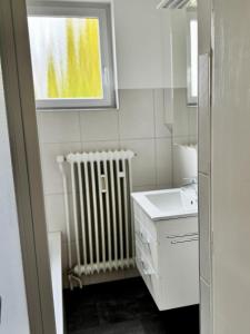 a bathroom with a radiator and a sink and a window at FeWo Pelkmann Apartment 2 - Die Grüne Oase - Garten & Balkon in Weikersheim +32 photos
