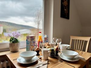 a wooden table with plates of food and a window at FeWo Pelkmann Apartment 2 - Die Grüne Oase - Garten & Balkon in Weikersheim