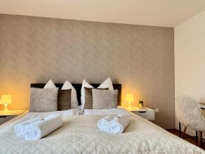 a bedroom with a large white bed with two pillows at FeWo Pelkmann Apartment 2 - Die Grüne Oase - Garten & Balkon in Weikersheim