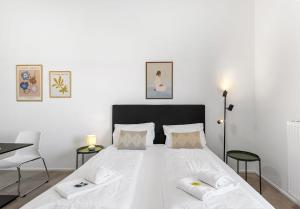 a bedroom with a large white bed with two chairs at SKYRISE Apartments mit Küche, WLAN & Parkplatz - ruhige Lage in Bad Wörishofen +29 photos
