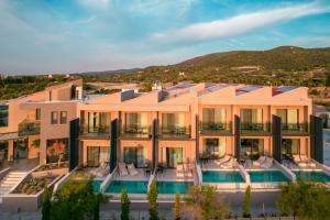 an exterior view of a building with a swimming pool at Anasa Luxury Resort in Elaiokhórion