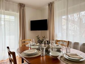 a dining room with a table with chairs and a television at FeWo Pelkmann Apartment 2 - Die Grüne Oase - Garten & Balkon in Weikersheim