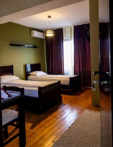 a bedroom with two beds and a table and a window at Pensiunea Aurelia in Şiria