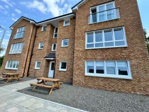 a building with a picnic table in front of it at Inchchlonaig Apartment in Bonhill