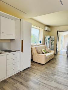 a living room with a couch and a kitchen at La Giara Guest House in Marina di Modica