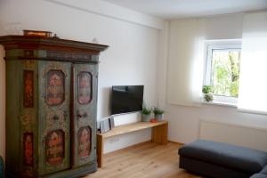 ein Wohnzimmer mit einem großen Holzschrank und einem TV in der Unterkunft Spa & Wellness Apartment Gerda in Grinzens