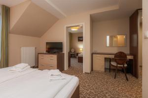 a hotel room with two beds and a desk at Hotel Green in Dolný Kubín